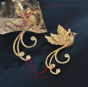 Macro detail of golden phoenix brooch featuring purple and yellow gradient zircon inlay