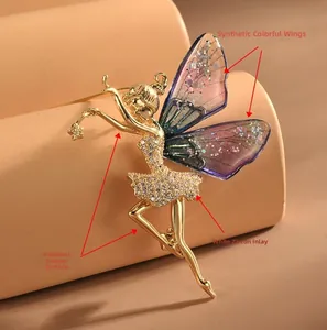 Vue détaillée d'une broche ballerine dorée avec ailes violettes et robe en zircon