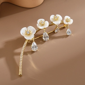 Elegant gold flower brooch with white mother of pearl and teardrop zircon crystals