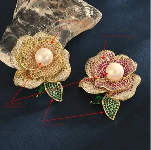 Vue détaillée de broches roses en zircon avec pétales superposés et perles d'imitation