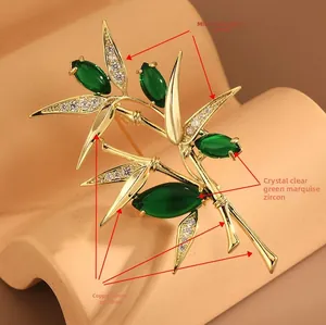 Détail de la broche bambou en cuivre poli avec zircon vert marquise et micro-pavage blanc