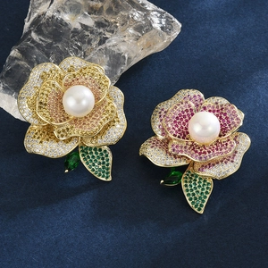 Broche élégante en forme de rose avec zircone et perle sur fond bleu texturé