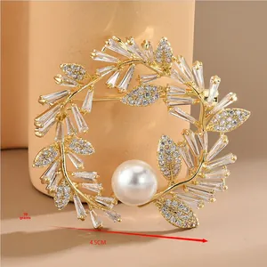 Vue détaillée de la broche couronne dorée avec zircons et perle blanche, taille 4,5 cm