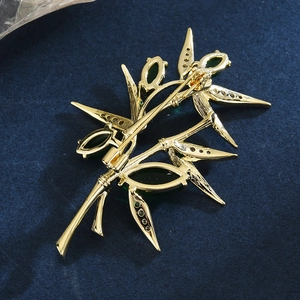 Broche en bambou dorée avec zircon vert et structure arrière évidée détaillée