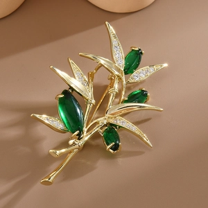 Élégante broche bambou dorée avec des pierres de zircon vert et cristaux brillants