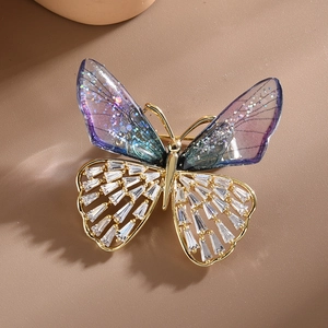 Elegant crystal butterfly brooch with purple resin wings and golden zircon stones