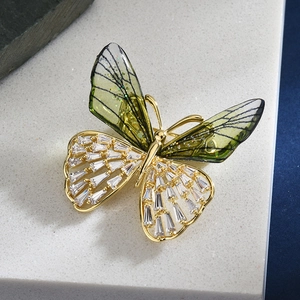 Elegant crystal butterfly brooch with green wings and golden zirconia accents for coats