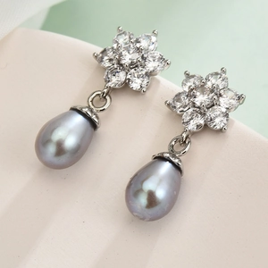 Elegant S925 silver pearl drop earrings with flower shape zircon stones on soft background