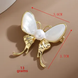 Vue détaillée d'une broche papillon avec nacre blanche et accents de perles imitation