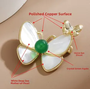Détail de la broche papillon avec ailes en nacre blanche et cœur en agate verte