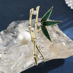 Spilla elegante in bambù dorato con smalto verde, perla bianca e cristalli scintillanti