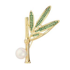 Broche bambou dorée élégante avec cristaux verts et une perle blanche ronde