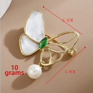 Detail of butterfly brooch with white mother of pearl and green marquise gemstone