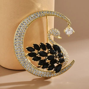 Golden crescent moon and swan brooch with black gemstones and micro-paved zircons