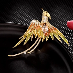 Macro detail of Phoenix brooch with gold plating and green enamel wing gradient
