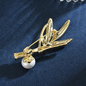 Broche élégante en bambou doré ornée de cristaux scintillants et d'une perle blanche