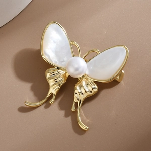 Broche papillon dorée élégante avec ailes en nacre blanche et incrustation de perle