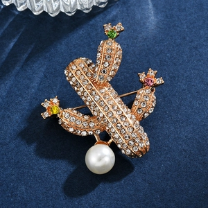 Broche cactus exquise avec strass, gemmes colorées et grande perle sur velours bleu marine