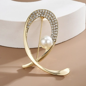 Elegant gold-tone brooch with white faux pearls and rhinestones on a stylish display