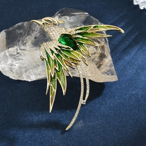 Elegant gold-plated phoenix brooch with green enamel wings and emerald green gemstone