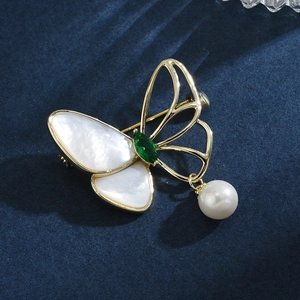 Elegant gold butterfly brooch with white shell wing, green gemstone and pearl pendant