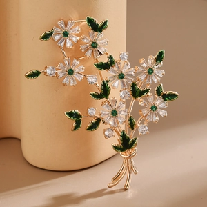 Détail de la broche bouquet de fleurs avec zircons brillants et feuilles en émail vert