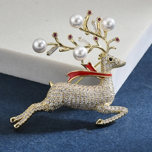 Détail d'une broche renne dorée avec pavage de zircons, écharpe en émail rouge et perles