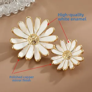 Vue macro de broches marguerites en émail blanc avec des bords en cuivre poli