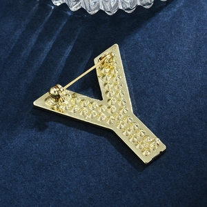 Broche lettre Y dorée élégante avec texture sur fond de velours bleu luxueux