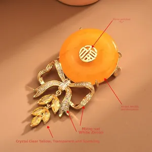 Close-up of bow brooch with Fu character amber and dangling yellow zircon tassels