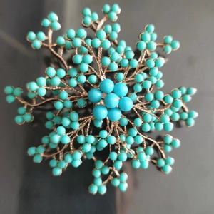 Élégante broche branche dorée avec perles bleu turquoise radieuses et centre floral