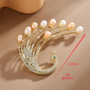 Detailed view of phoenix brooch featuring freshwater pearls and zircon stones