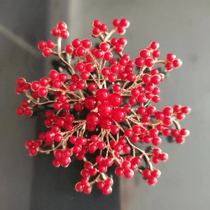 Broche fleurie en or avec grappes de perles rouges pour tenues de fête élégantes