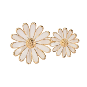 Broche marguerite en émail blanc avec deux fleurs et détails dorés métalliques polis