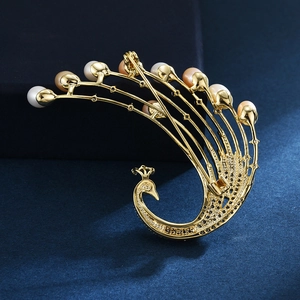 Elegant gold phoenix brooch featuring freshwater pearls and sparkling zircon accents