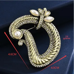 Macro shot of 4.6cm twisted gold rope brooch with pearls and rhinestones detail
