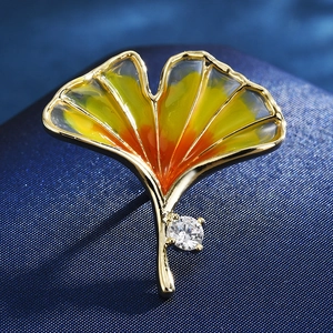 Macro shot of ginkgo leaf brooch with yellow gradient enamel and sparkling crystal