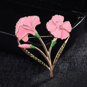 Macro view of carnation brooch featuring pink enamel petals and sparkling green rhinestones