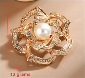 Detailed view of camellia brooch with gold petals, micro-pave crystals and a center pearl