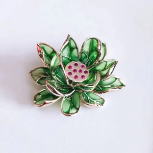 Nahaufnahme der Lotus-Brosche mit grünem Emaille und rosa Schmuckstein-Staubblättern