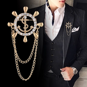 Golden ship helm brooch with rhinestones and chains on a black pinstripe suit