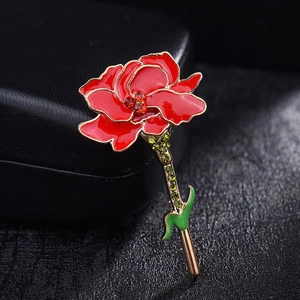 Elegant red carnation brooch with gold trim and green crystals on black leather box