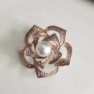 Detailed close-up of rose gold camellia brooch with multi-layer petals and pearl center
