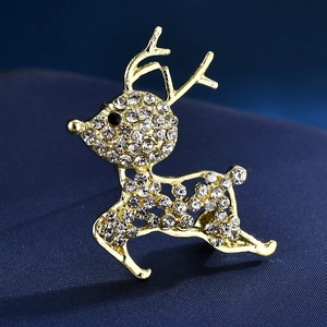 Vue macro d'une broche cerf dorée avec cristaux sur un fond de tissu bleu marine texturé