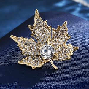 Macro detail of maple leaf brooch featuring gold alloy base and sparkling crystals
