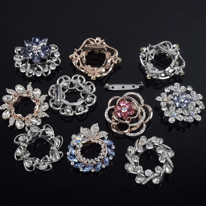 Macro view of crystal flower brooches and scarf rings in silver and rose gold finishes