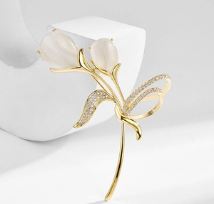 Détail d'une broche tulipe dorée avec pierres œil de chat et zircons étincelants
