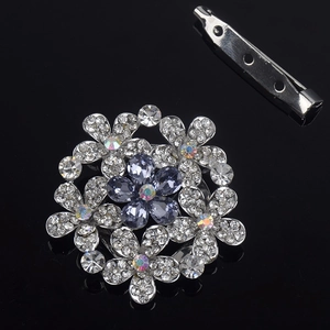 Detailed view of flower brooch with blue zircon petals and silver alloy finish