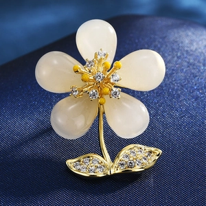 Detailed close-up of ginkgo leaf brooch with white opal petals and sparkling diamonds