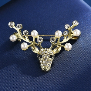 Vue détaillée d'une broche renne avec perles et strass sur un tissu bleu